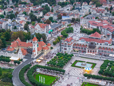 Aerial view of the historic spa house and vibrant town square with a carousel manicured gardens and surrounding urban architecture in Sopot Pomeranian Voivodeship Poland. Aerial view of the historic spa house and vibrant town square with a carousel manicured gardens and surrounding urban architecture in Sopot Pomeranian Voivodeship Poland.