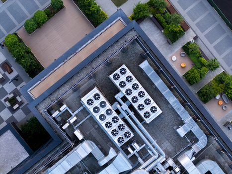 Aerial view of modern building rooftop featuring industrial HVAC units ventilation ducts and landscaped terrace areas with paving and greenery in Poland. Aerial view of modern building rooftop featuring industrial HVAC units ventilation ducts and landscaped terrace areas with paving and greenery in Poland.