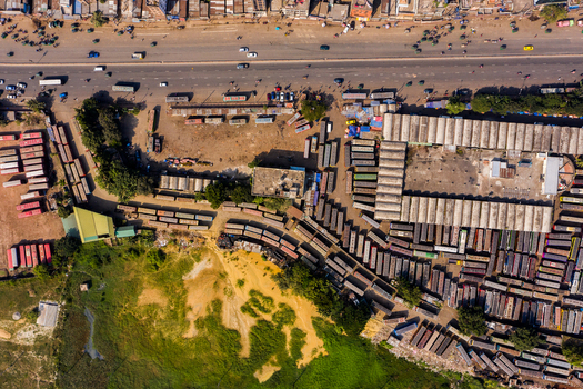 Aerial view of Gabtoli Bus Terminal with rows of parked buses terminal buildings with corrugated roofs and adjacent highway traffic in Dhaka Dhaka Division Bangladesh.