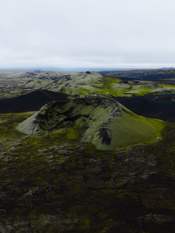 Aerial view of moss covered volcanic cones rise dramatically from the stark landscape under a hazy sky Lakagigar Iceland. Aerial view of moss covered volcanic cones rise dramatically from the stark landscape under a hazy sky Lakagigar Iceland.