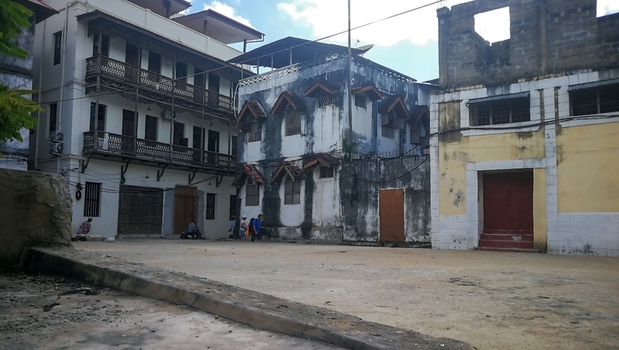 View of historic buildings with traditional wooden balconies and weathered facades in a quiet square in Zanzibar Mjini Magharibi Regio Tanzania. View of historic buildings with traditional wooden balconies and weathered facades in a quiet square in Zanzibar Mjini Magharibi Regio Tanzania.