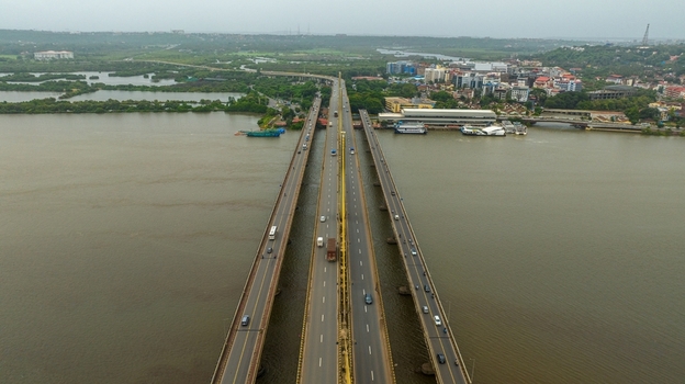 Aerial view of Atal Setu Goa bridge spanning the Mandovi River with traffic and surrounding urban landscape in Panaji Goa India.