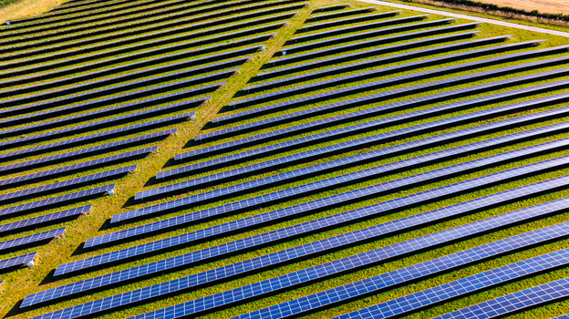 Aerial view of a large solar farm with rows of photovoltaic panels arranged in neat lines across a grassy field in Dorset England United Kingdom. Aerial view of a large solar farm with rows of photovoltaic panels arranged in neat lines across a grassy field in Dorset England United Kingdom.