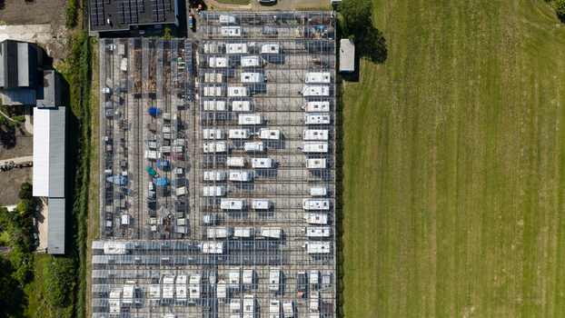 Aerial view of Caravanstalling Klijn a large glass roofed storage facility filled with rows of parked caravans situated next to green fields in Alkmaar Noord Holland Netherlands. Aerial view of Caravanstalling Klijn a large glass roofed storage facility filled with rows of parked caravans situated next to green fields in Alkmaar Noord Holland Netherlands.