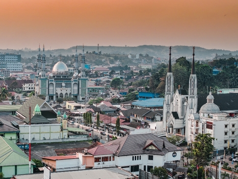 Aerial view of Nurul Mu minin Mosque and Saint Mary of Perpetual Help Cathedral standing side by side in the urban landscape of Samarinda East Kalimantan Indonesia. Aerial view of Nurul Mu minin Mosque and Saint Mary of Perpetual Help Cathedral standing side by side in the urban landscape of Samarinda East Kalimantan Indonesia.