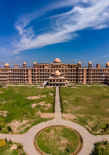 Aerial view of the University of Peshawar featuring grand historic architecture arched corridors and expansive green lawns in Peshawar Khyber Pakhtunkhwa Pakistan.
