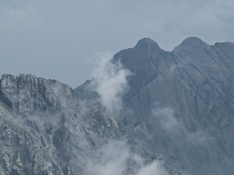 Aerial view of the rugged Apuan Alps marble mountains with jagged peaks and wispy clouds in Carrara Tuscany Italy. Aerial view of the rugged Apuan Alps marble mountains with jagged peaks and wispy clouds in Carrara Tuscany Italy.