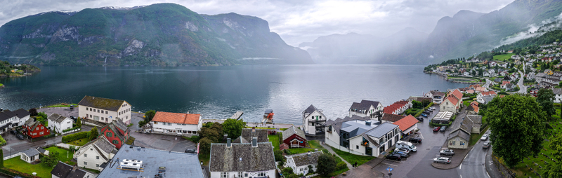 Aerial view of the village of Flam nestled along the Aurlandsfjord with surrounding mountains lush greenery and traditional buildings in Flam Vestland Norway. Aerial view of the village of Flam nestled along the Aurlandsfjord with surrounding mountains lush greenery and traditional buildings in Flam Vestland Norway.