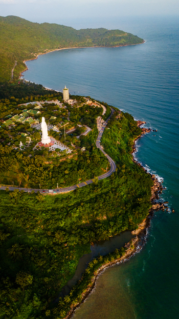 Aerial view of Linh Ung Pagoda with its large white Buddha statue and pagoda tower on the lush Son Tra Peninsula overlooking the ocean Da Nang Vietnam. Aerial view of Linh Ung Pagoda with its large white Buddha statue and pagoda tower on the lush Son Tra Peninsula overlooking the ocean Da Nang Vietnam.