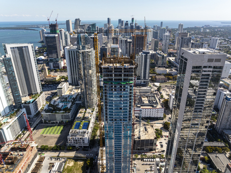 Aerial view of towering skyscrapers reaching for the sky amidst a sprawling cityscape with the ocean shimmering in the distance Miami Florida USA. Aerial view of towering skyscrapers reaching for the sky amidst a sprawling cityscape with the ocean shimmering in the distance Miami Florida USA.