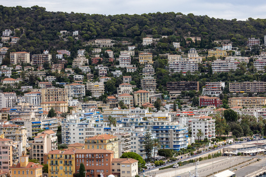 Aerial view of the urban landscape of Nice featuring numerous residential buildings dense hillside vegetation and city streets in Nice Provence Alpes Cote d Azur France. Aerial view of the urban landscape of Nice featuring numerous residential buildings dense hillside vegetation and city streets in Nice Provence Alpes Cote d Azur France.