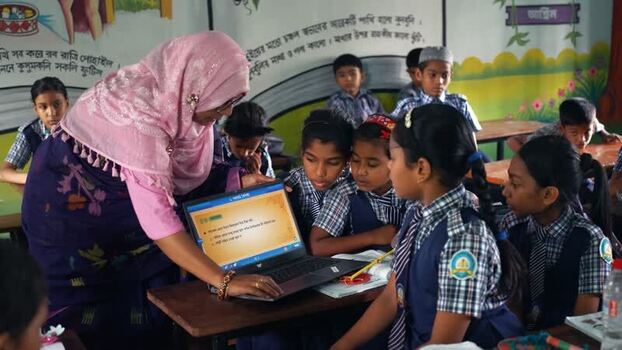 View of a teacher showing a laptop to students in Bogura Bangladesh.