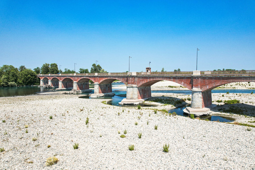 Aerial view of the historic brick Ponte Crescentino spanning the dry riverbed of the Po River during a severe drought in Verrua Savoia Piemonte Italy. Aerial view of the historic brick Ponte Crescentino spanning the dry riverbed of the Po River during a severe drought in Verrua Savoia Piemonte Italy.