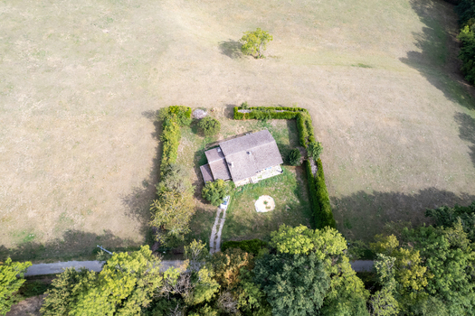 Aerial view of an isolated house surrounded by a green hedge and trees in a rural field in France. Aerial view of an isolated house surrounded by a green hedge and trees in a rural field in France.