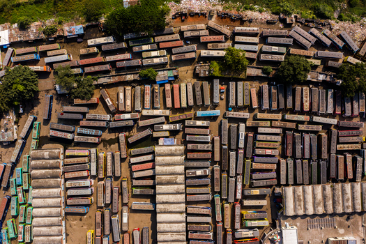 Aerial view of Gabtoli Bus Terminal with rows of parked buses arranged in organized lanes surrounded by trees and urban infrastructure in Dhaka Dhaka Division Bangladesh.