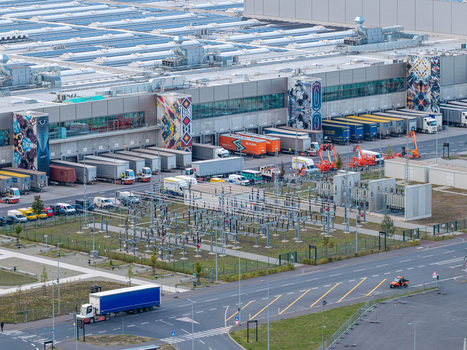 Aerial view of Tesla Gigafactory Berlin Brandenburg showing the industrial facility with trucks at loading docks a power substation and surrounding roads. Aerial view of Tesla Gigafactory Berlin Brandenburg showing the industrial facility with trucks at loading docks a power substation and surrounding roads.