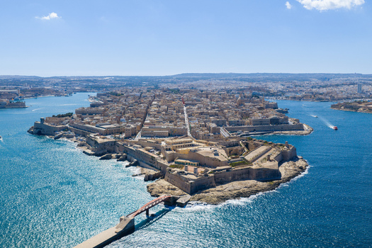 Aerial view of the historic city of Valletta featuring its fortified walls dense urban architecture and the blue waters of the Grand Harbour in Valletta Port Region Malta. Aerial view of the historic city of Valletta featuring its fortified walls dense urban architecture and the blue waters of the Grand Harbour in Valletta Port Region Malta.