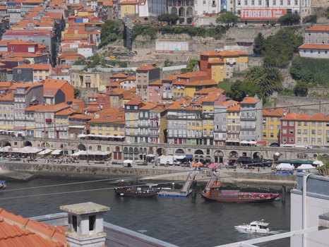 View of the historic Ribeira district with colorful buildings traditional rabelo boats on the Douro River and terracotta rooftops in Porto Porto District Portugal. View of the historic Ribeira district with colorful buildings traditional rabelo boats on the Douro River and terracotta rooftops in Porto Porto District Portugal.