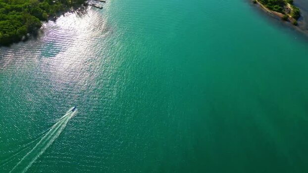 Aerial view of a boat in turquoise water Honduras.
