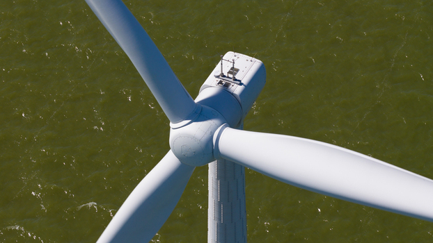 Aerial view of Windpark Fryslan wind turbine blades rotating above the water in Breezanddijk Friesland Netherlands. Aerial view of Windpark Fryslan wind turbine blades rotating above the water in Breezanddijk Friesland Netherlands.