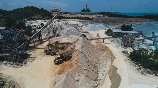Aerial view of a sand mining site with heavy machinery piles of sand and conveyor belts in Karimun Kepulauan Riau Indonesia. Aerial view of a sand mining site with heavy machinery piles of sand and conveyor belts in Karimun Kepulauan Riau Indonesia.
