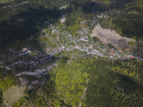 Aerial view of the historic mining village of Spania Dolina nestled among lush green forests and rolling hills under soft sunlight Spania Dolina Banska Bystrica Regio Slovakia.