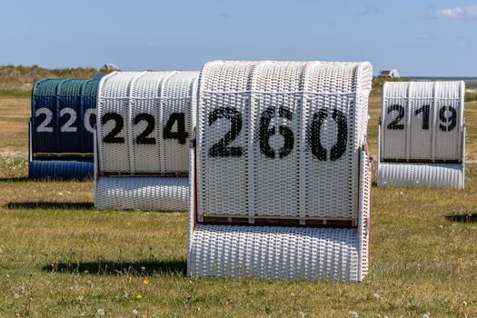 View of traditional numbered wicker beach chairs at Strand Schillig on a sunny day in Wangerland Niedersachsen Germany. View of traditional numbered wicker beach chairs at Strand Schillig on a sunny day in Wangerland Niedersachsen Germany.