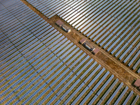 Aerial view of rows of solar panels in a large photovoltaic power plant with utility buildings and dirt tracks Manacor Balearic Islands Spain. Aerial view of rows of solar panels in a large photovoltaic power plant with utility buildings and dirt tracks Manacor Balearic Islands Spain.