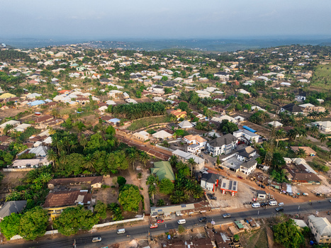 Aerial view of houses nestled among lush greenery and a visible road creating a harmonious blend of urban and natural elements Elu Abia Nigeria. Aerial view of houses nestled among lush greenery and a visible road creating a harmonious blend of urban and natural elements Elu Abia Nigeria.