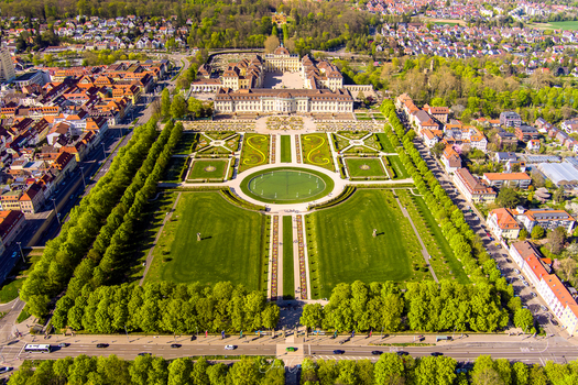 Aerial view of Ludwigsburg Palace with its extensive baroque gardens manicured lawns geometric flower beds and surrounding urban landscape in Ludwigsburg Baden Wurttemberg Germany.