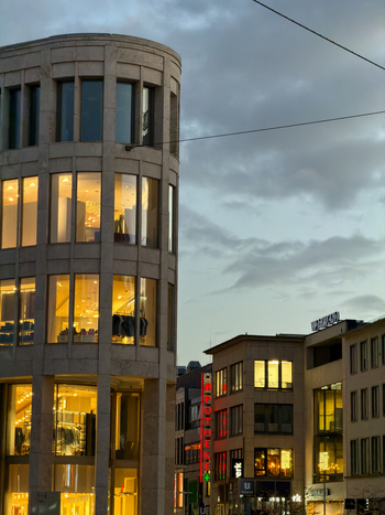 Hanover Germany 30 March 2026 View of modern stone architecture with illuminated windows in the city center at dusk under a cloudy sky.