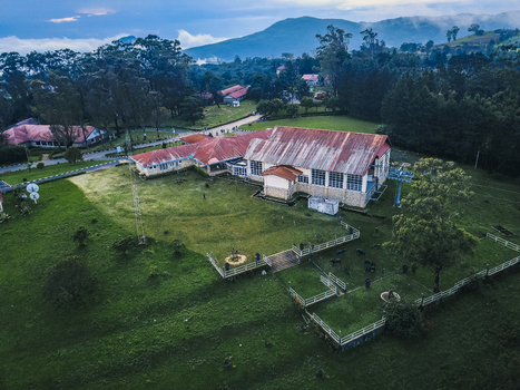 Aerial view of a sprawling building with a weathered roof contrasting against the lush green landscape and distant misty mountains Obudu Cross River Nigeria.