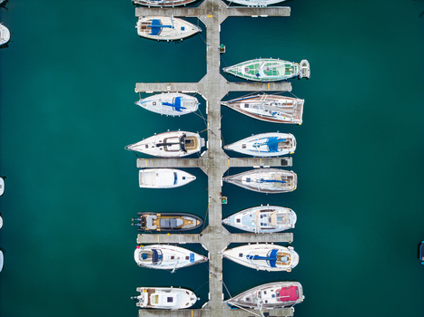 Aerial view of sailboats and motorboats moored at the docks in Bangor Harbour with calm turquoise water and wooden piers in Bangor Northern Ireland United Kingdom.