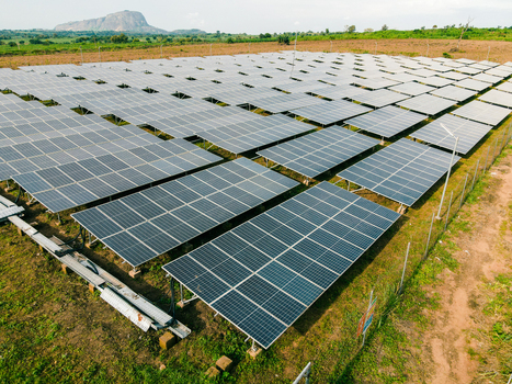 Aerial view of a large solar farm with rows of photovoltaic panels installed in a rural landscape in Ogun State Nigeria.