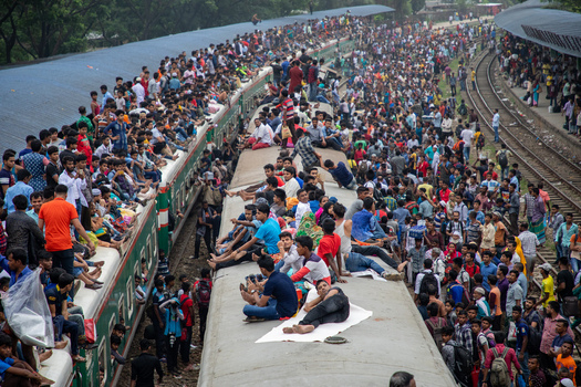 Dhaka Bangladesh 15 June 2018 View of Airport Railway Station with a massive crowd of people sitting on the roofs of trains and standing on platforms during Eid al Fitr travel. Dhaka Bangladesh 15 June 2018 View of Airport Railway Station with a massive crowd of people sitting on the roofs of trains and standing on platforms during Eid al Fitr travel.