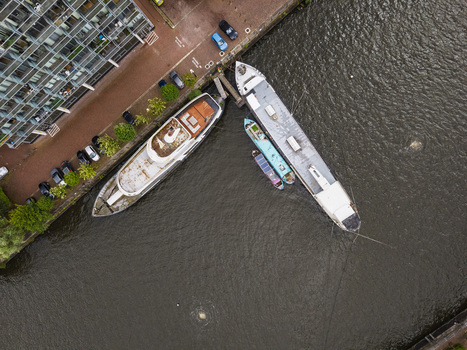 Aerial view of MediaCityUK showing boats moored along the canal bank with modern apartment buildings and parked cars nearby in Salford England United Kingdom. Aerial view of MediaCityUK showing boats moored along the canal bank with modern apartment buildings and parked cars nearby in Salford England United Kingdom.