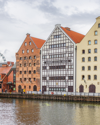 Gdansk Poland 05 September 2026 View of the historic National Maritime Museum and traditional brick warehouses along the Motlawa River waterfront under a cloudy sky. Gdansk Poland 05 September 2026 View of the historic National Maritime Museum and traditional brick warehouses along the Motlawa River waterfront under a cloudy sky.