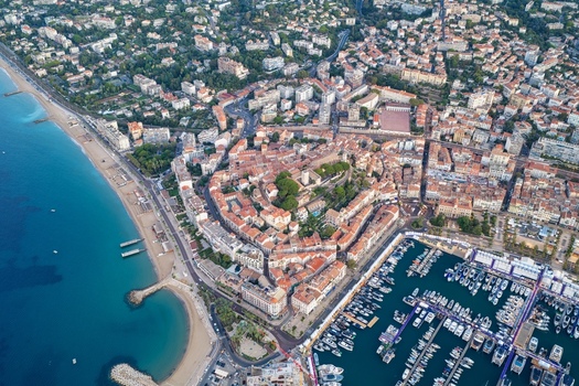 Aerial view of the historic Le Suquet district the bustling marina filled with yachts and the sandy coastline of the Mediterranean Sea in Cannes Provence Alpes Cote d Azur France. Aerial view of the historic Le Suquet district the bustling marina filled with yachts and the sandy coastline of the Mediterranean Sea in Cannes Provence Alpes Cote d Azur France.