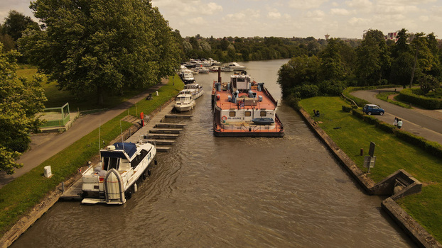 Aerial view of a barge and pleasure boats navigating the canal in Saint Omer Hauts de France France. Aerial view of a barge and pleasure boats navigating the canal in Saint Omer Hauts de France France.