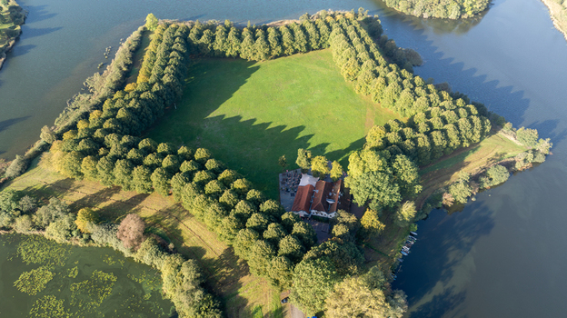 Aerial view of the star shaped Pettelaarse Schans surrounded by water lush green trees and a historic building in s Hertogenbosch Noord Brabant Netherlands. Aerial view of the star shaped Pettelaarse Schans surrounded by water lush green trees and a historic building in s Hertogenbosch Noord Brabant Netherlands.