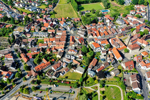 Aerial view of the historic town center with red tiled rooftops green gardens and the parish church in Neunkirchen am Brand Bavaria Germany. Aerial view of the historic town center with red tiled rooftops green gardens and the parish church in Neunkirchen am Brand Bavaria Germany.