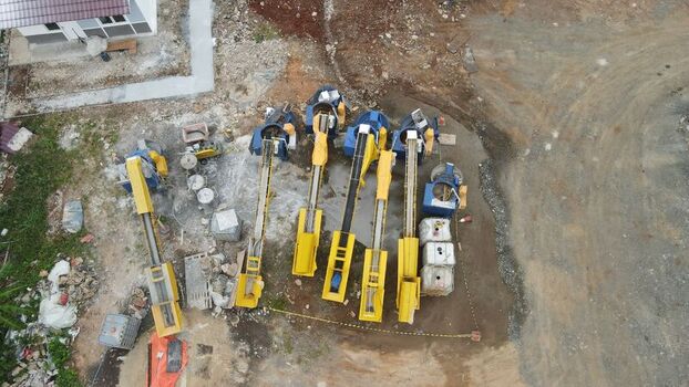 Aerial view of construction machinery including yellow conveyor belts and mixers positioned on a dirt site at Bambu Apus in Kecamatan Cipayung Daerah Khusus Ibukota Indonesia. Aerial view of construction machinery including yellow conveyor belts and mixers positioned on a dirt site at Bambu Apus in Kecamatan Cipayung Daerah Khusus Ibukota Indonesia.
