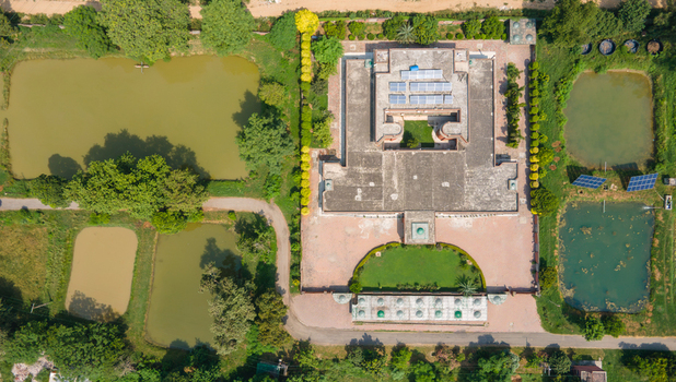 Lahore Pakistan 08 September 2026 Aerial view of a large government building data canter complex featuring solar panels on the roof surrounded by multiple ponds manicured lawns and lush trees.
