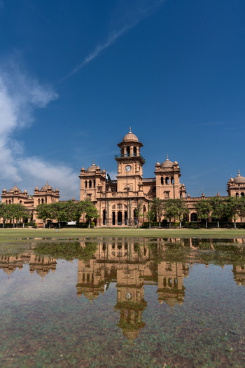 View of the historic Islamia College University Peshawar building reflected in a pool of water on the lawn under a clear blue sky in Peshawar Khyber Pakhtunkhwa Pakistan. View of the historic Islamia College University Peshawar building reflected in a pool of water on the lawn under a clear blue sky in Peshawar Khyber Pakhtunkhwa Pakistan.