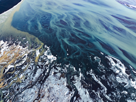 Aerial view of the intricate patterns of a glacial river delta with sediment laden water melting ice and snow covered terrain in Iceland. Aerial view of the intricate patterns of a glacial river delta with sediment laden water melting ice and snow covered terrain in Iceland.
