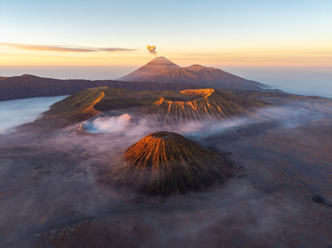 Aerial view of Mount Bromo with its volcanic crater surrounding caldera and misty landscape at sunrise in Tosari East Java Indonesia.