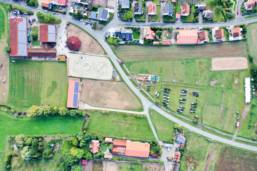 Aerial view of Reitclub In der Point Poxdorf featuring stables outdoor riding arenas and lush green fields in Poxdorf Bayern Germany. Aerial view of Reitclub In der Point Poxdorf featuring stables outdoor riding arenas and lush green fields in Poxdorf Bayern Germany.