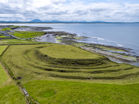 Aerial view of the historic hut site with grassy earthworks and ancient fortifications overlooking the rugged coastline of Enniscrone County Sligo Ireland. Aerial view of the historic hut site with grassy earthworks and ancient fortifications overlooking the rugged coastline of Enniscrone County Sligo Ireland.