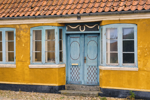 Ribe Denmark 20 July 2026 View of colorful doors and blue framed windows on a vibrant yellow historic house in the old town of Ribe.