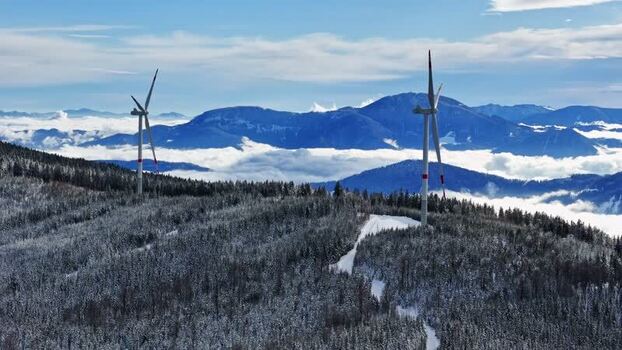 Aerial view of wind turbines on a snowy mountain ridge Austria. Aerial view of wind turbines on a snowy mountain ridge Austria.